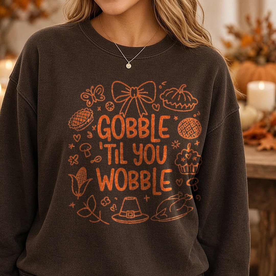 Gobble Til You Wobble Orange Line Art Thanksgiving Doodles DTF transfer shown on a Comfort Colors sweatshirt