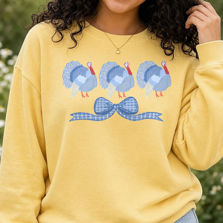 Three Blue Floral Turkeys with Gingham Bow DTF transfer shown on a Comfort Colors sweatshirt