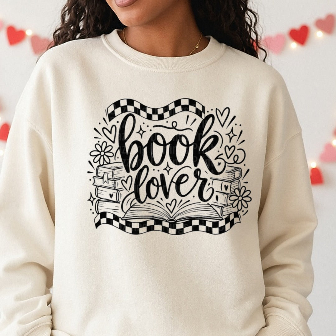 Book Lover Script with Stacked Books and Checkered Banner DTF transfer shown on a Comfort Colors sweatshirt