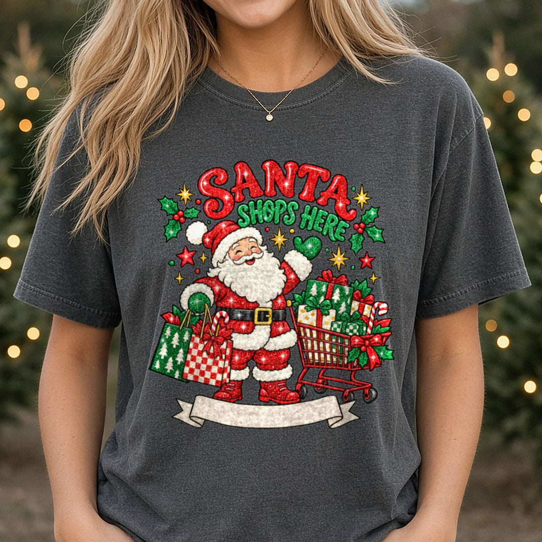 Santa Shops Here Glitter Santa with Shopping Cart and Gifts DTF transfer shown on a Comfort Colors tee