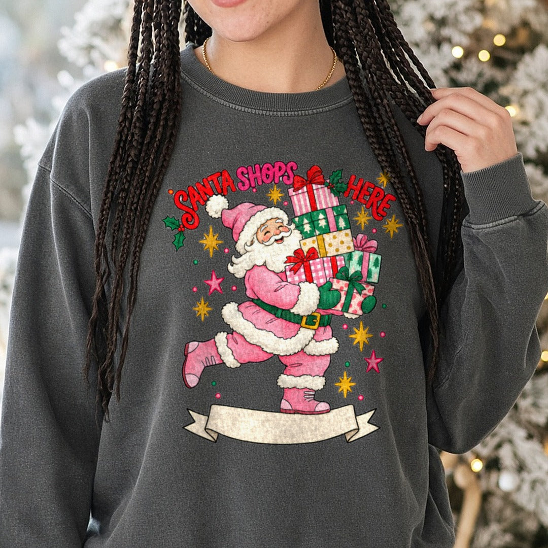 Santa Shops Here Pink Santa Claus Carrying Gifts Banner DTF transfer shown on a Comfort Colors sweatshirt