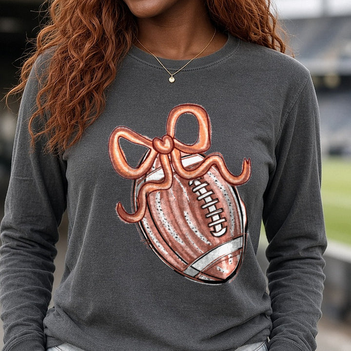 Football Coquette Bow Watercolor DTF transfer shown on a Comfort Colors long sleeve tee
