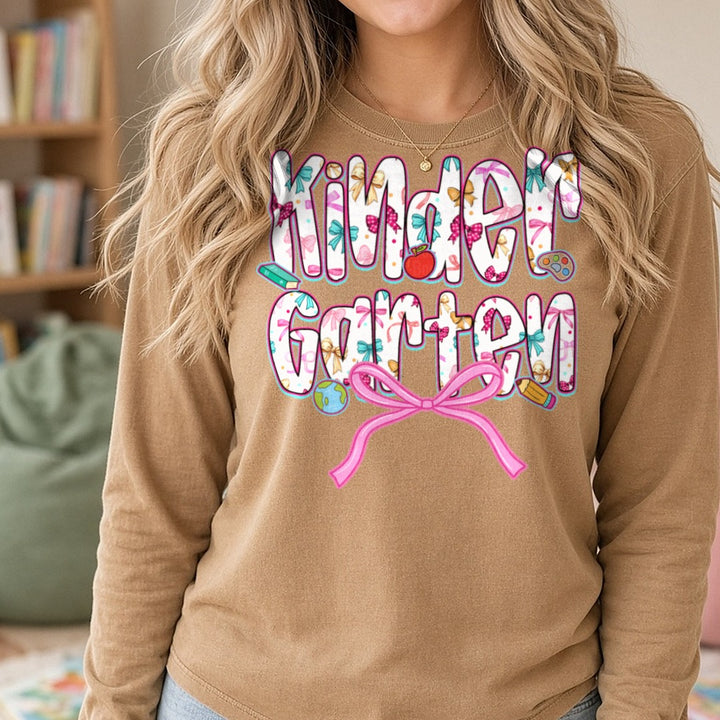 Back To School Kindergarten Floral Letters Pink Bow Apple DTF transfer shown on a Comfort Colors long sleeve tee