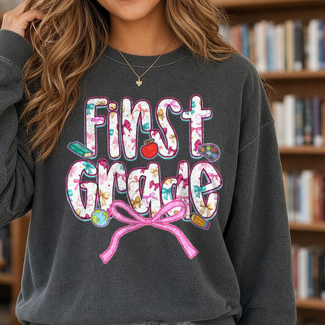 Back To School First Grade Floral Letters Pink Bow Apple DTF transfer shown on a Comfort Colors sweatshirt