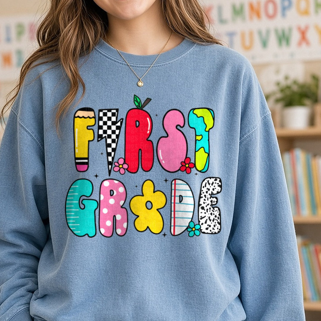 Back to School Teacher 1st Doodles DTF transfer shown on a Comfort Colors sweatshirt
