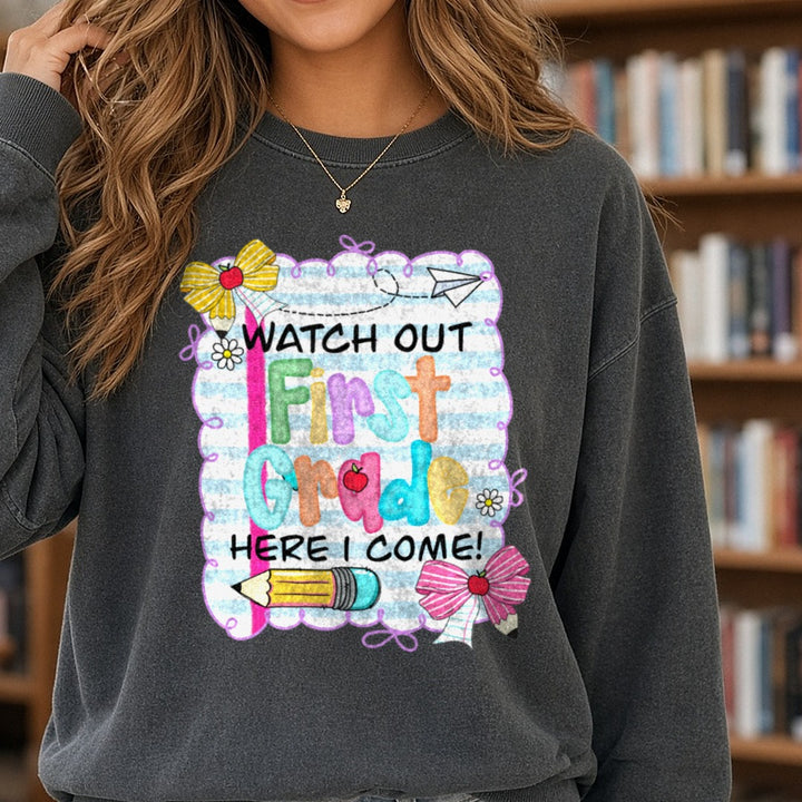 Back to School Teacher Watch Out Here I Come First Grade DTF transfer shown on a Comfort Colors sweatshirt