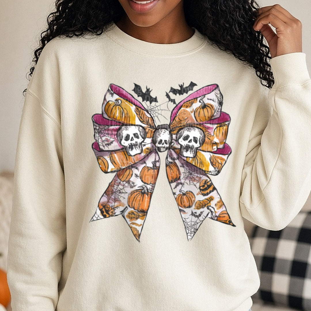 Halloween Fall Coquette Bow Pink Cream Pumpkins Twin Skulls DTF transfer shown on a Comfort Colors sweatshirt