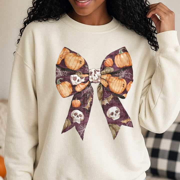 Halloween Fall Coquette Bow Burgundy Pumpkins Skulls Webs DTF transfer shown on a Comfort Colors sweatshirt