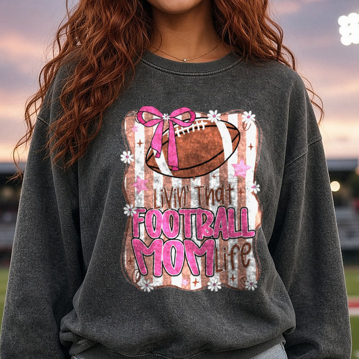 Livin That Football Mom Life Pink Bow Brown Stripes DTF transfer shown on a Comfort Colors sweatshirt