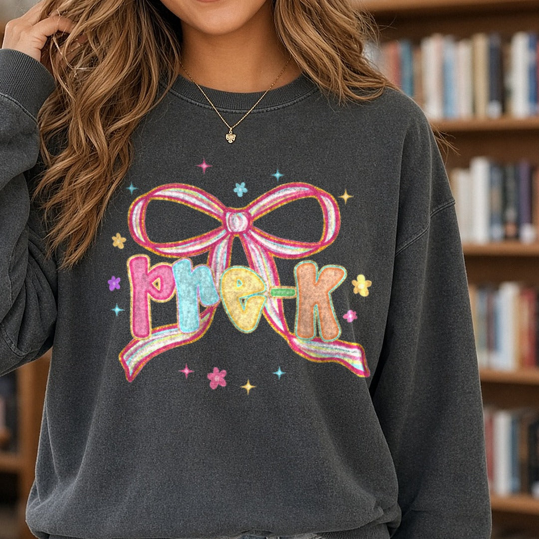 Pre-K Pastel Bow Glitter Letters DTF transfer shown on a Comfort Colors sweatshirt