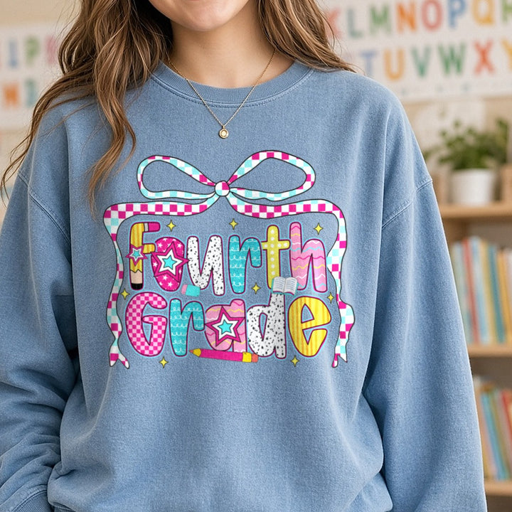 Fourth Grade Checkered Ribbon Bow Patterned Letters DTF transfer shown on a Comfort Colors sweatshirt