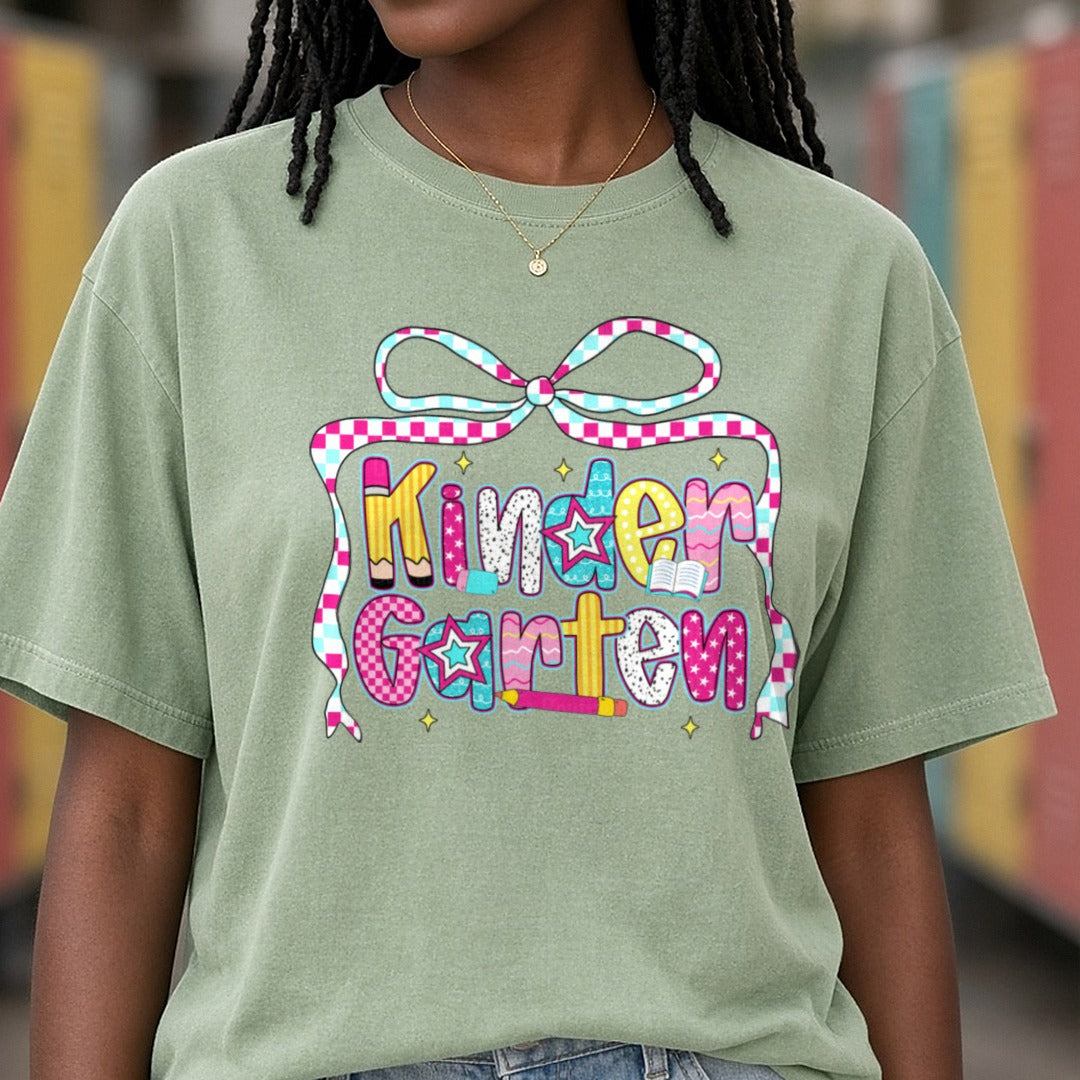 Kindergarten Checkered Ribbon Bow Patterned Letters DTF transfer shown on a Comfort Colors tee