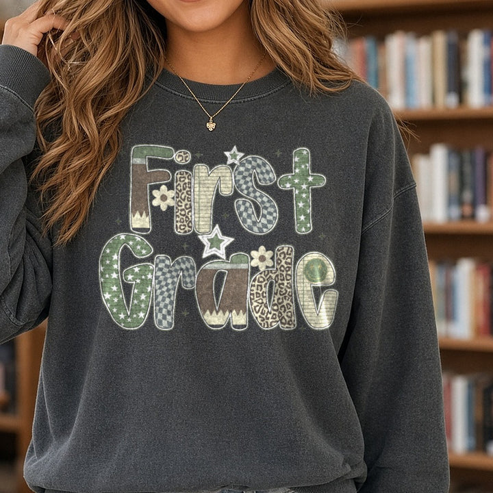 First Grade Camo Patterned Letters Stars Leopard DTF transfer shown on a Comfort Colors sweatshirt