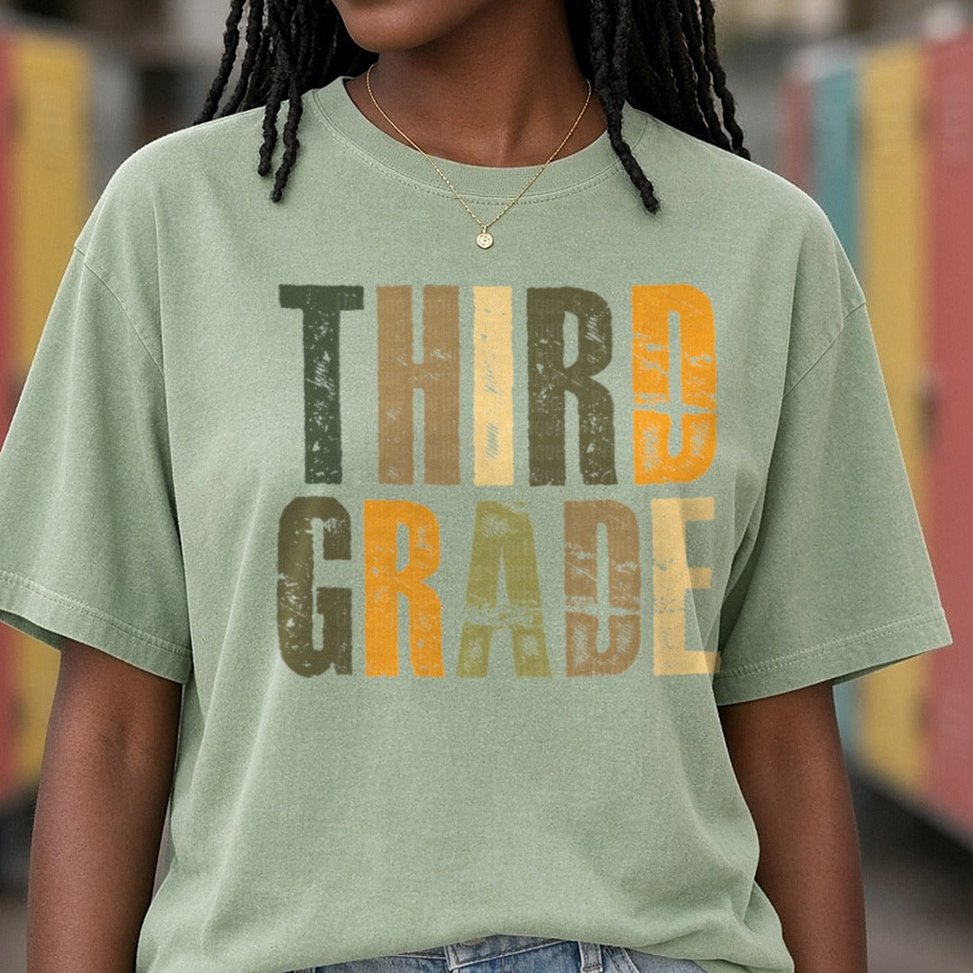Third Grade Distressed Green Orange Block Letters DTF transfer shown on a Comfort Colors tee