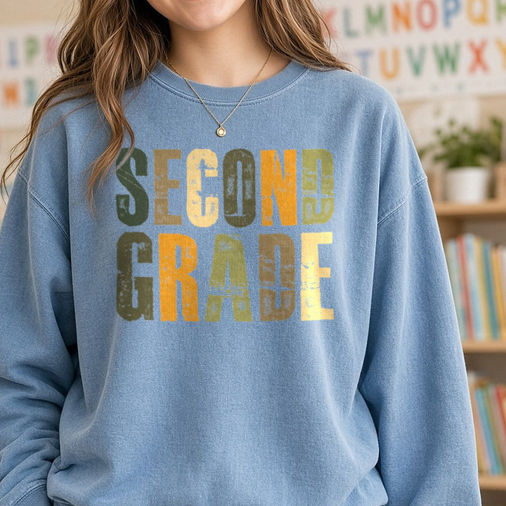 Second Grade Distressed Green Orange Block Letters DTF transfer shown on a Comfort Colors sweatshirt