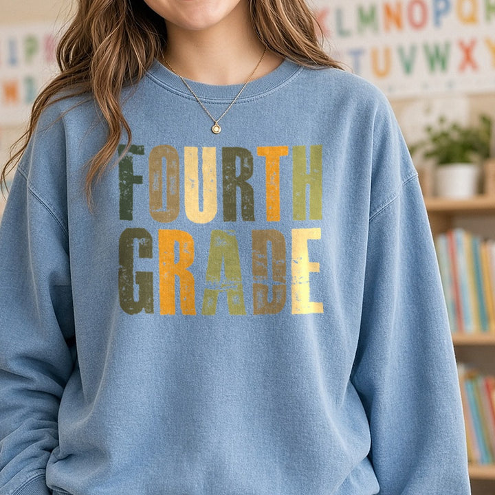 Fourth Grade Distressed Green Orange Block Letters DTF transfer shown on a Comfort Colors sweatshirt
