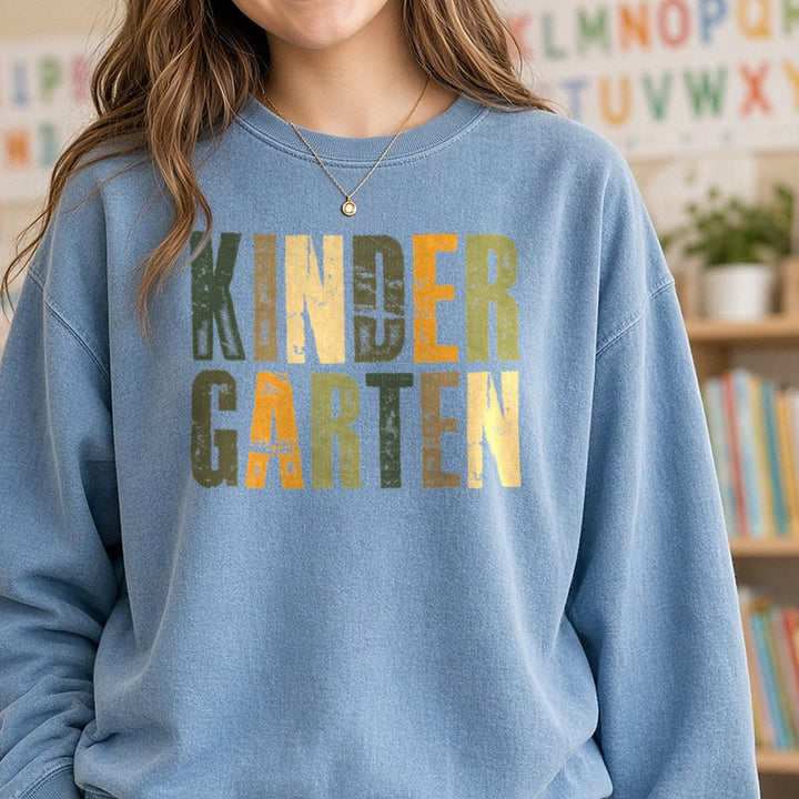 Kindergarten Distressed Green Orange Block Letters DTF transfer shown on a Comfort Colors sweatshirt
