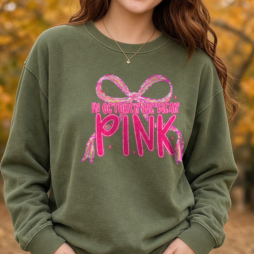 Breast Cancer Awareness Coquette Ribbon in October We Wear Pink DTF transfer shown on a Comfort Colors sweatshirt