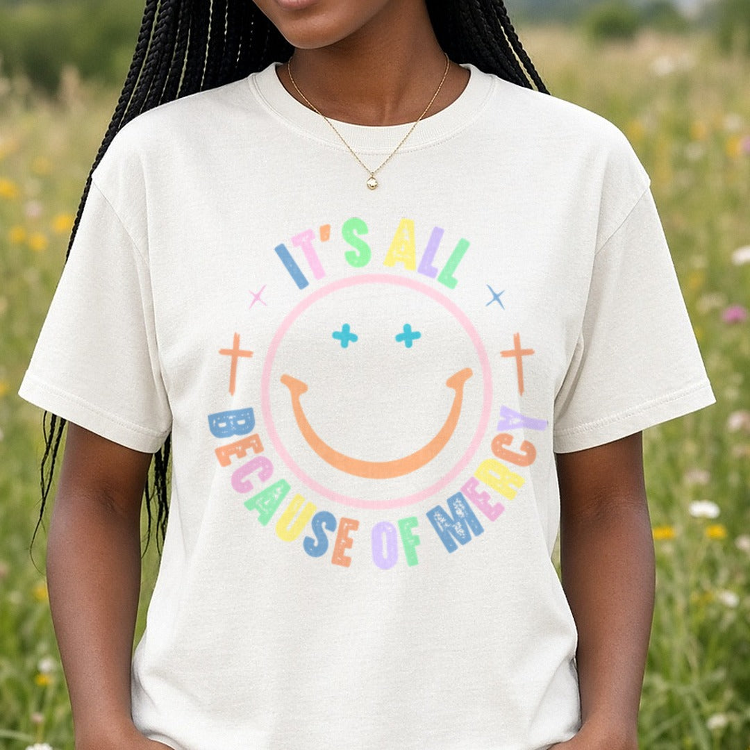 It's All Because of Mercy Smiley DTF transfer shown on a Comfort Colors tee
