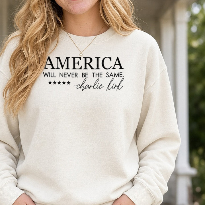 America Will Never Be The Same Charlie Kirk Black Serif Script DTF transfer shown on a Comfort Colors sweatshirt