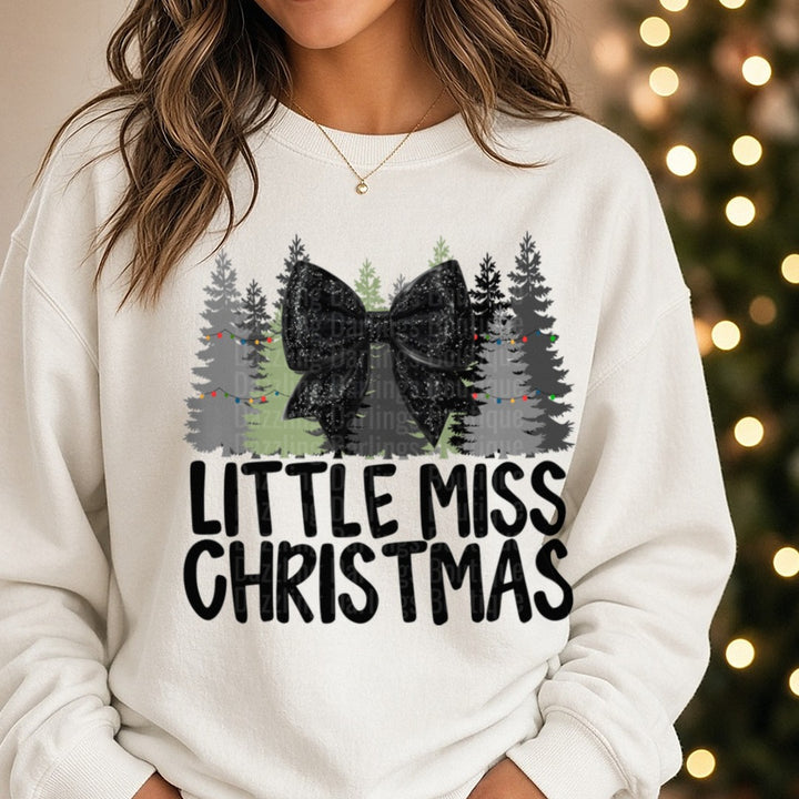 Black Bow Little Miss Christmas DTF transfer shown on a Comfort Colors sweatshirt