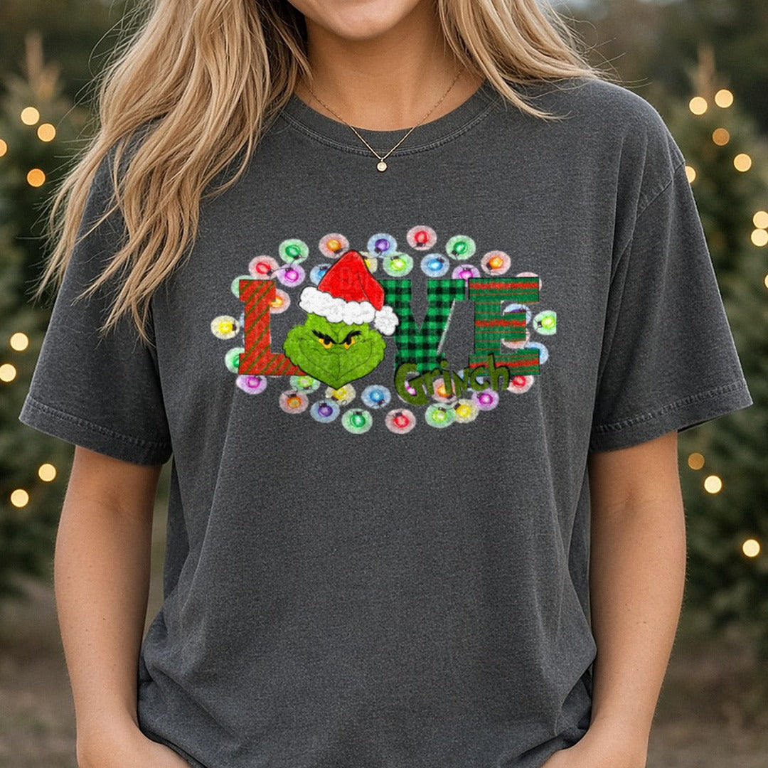 LOVE Grinch Buffalo Plaid Christmas Lights DTF transfer shown on a Comfort Colors tee