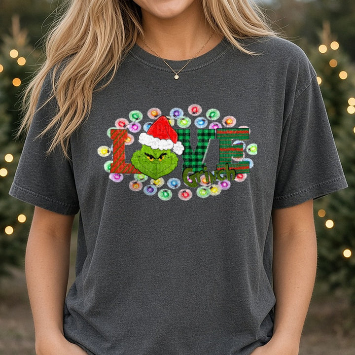 LOVE Grinch Buffalo Plaid Christmas Lights DTF transfer shown on a Comfort Colors tee