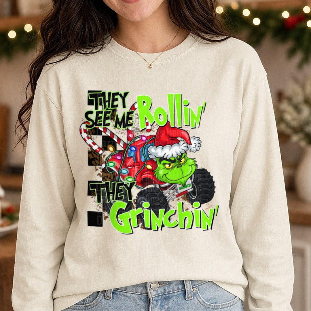 They See Me Rollin' They Grinchin' Monster Truck Christmas DTF transfer shown on a Comfort Colors long sleeve tee