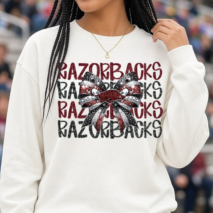Razorbacks Repeat Text Glitter Bow DTF transfer shown on a Comfort Colors sweatshirt