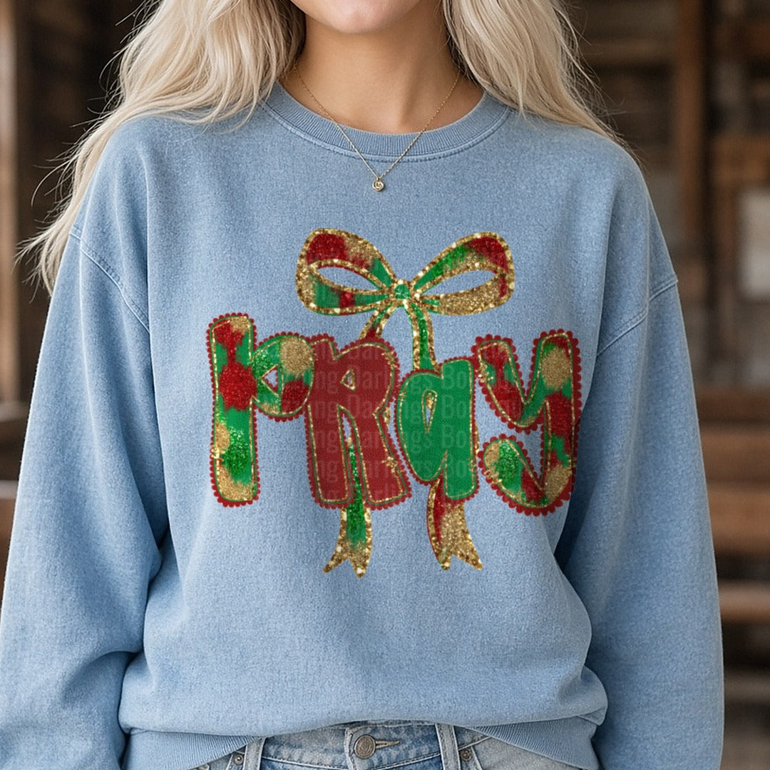 Pray Christmas Glitter Bow Plaid Letters DTF transfer shown on a Comfort Colors sweatshirt