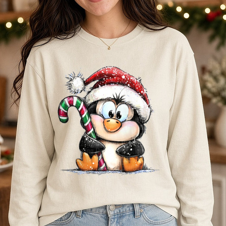 Hand-drawn Christmas Penguin Santa Hat Candy Cane Sitting DTF transfer shown on a Comfort Colors long sleeve tee