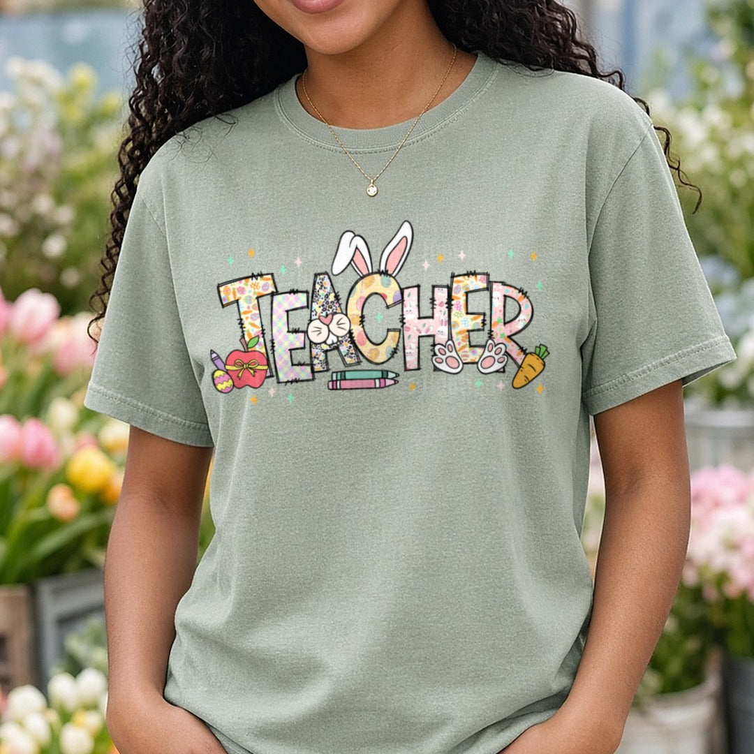 Easter Teacher Bunny Ears Letters with School Supplies DTF transfer shown on a Comfort Colors tee