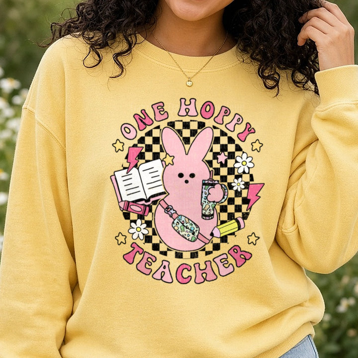 One Hoppy Teacher Pink Bunny with School Supplies Design DTF transfer shown on a Comfort Colors sweatshirt