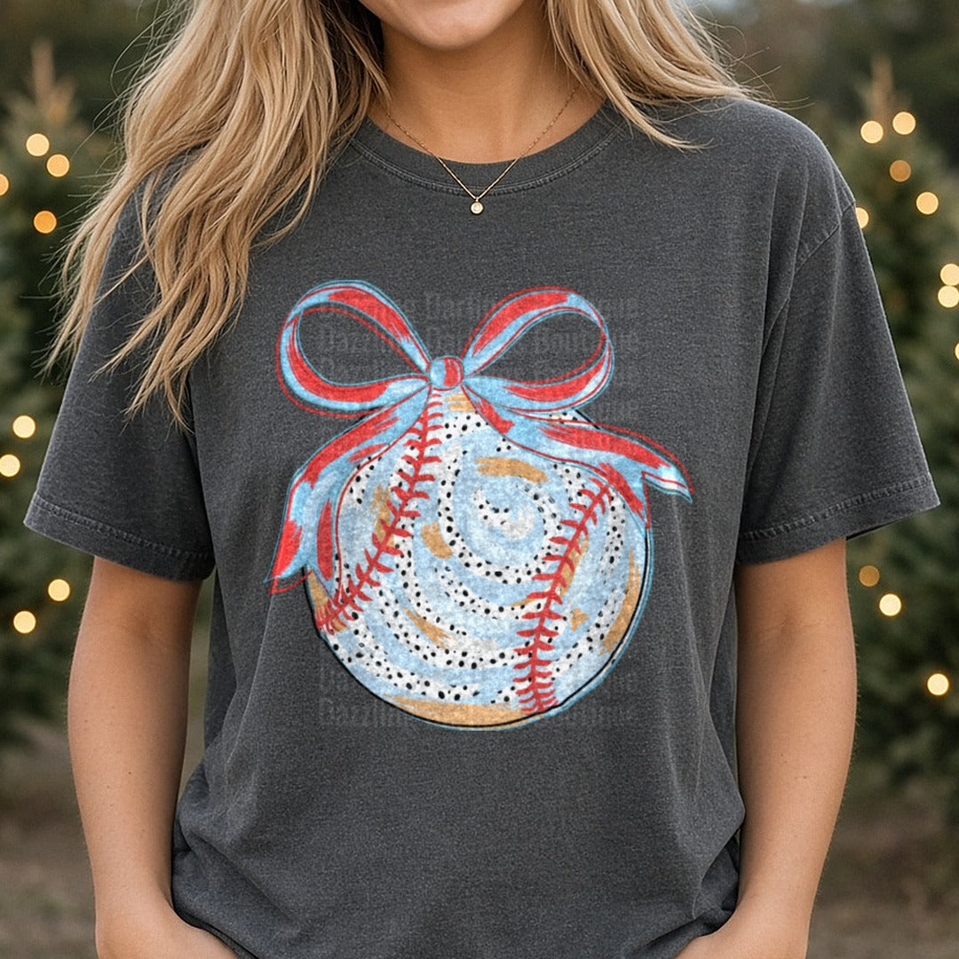 Baseball Christmas Ornament with Red White Blue Ribbon Bow DTF transfer shown on a Comfort Colors tee
