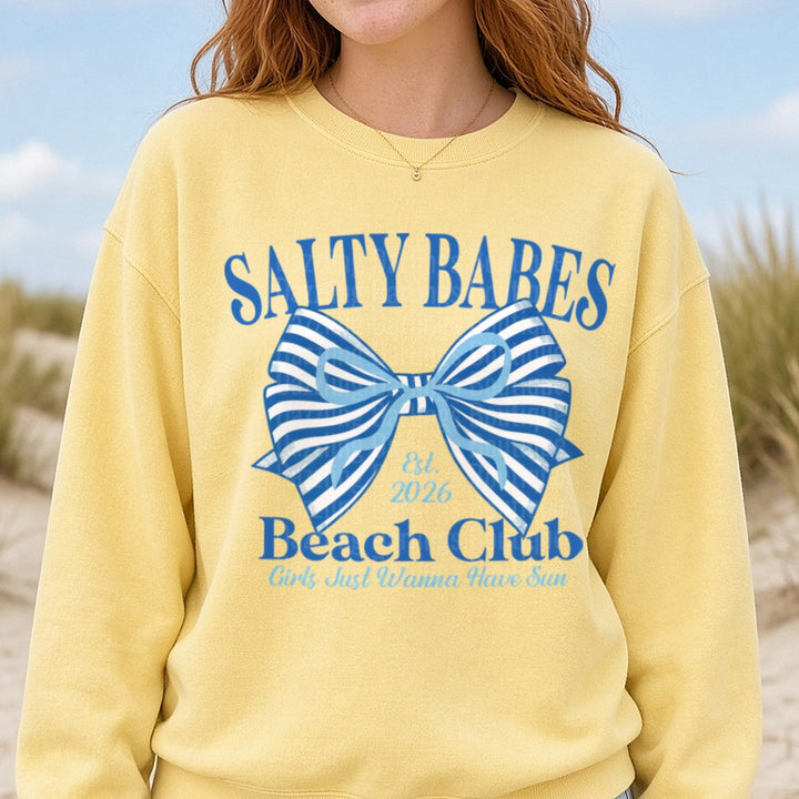 Salty Babes Beach Club Est 2026 Blue Striped Bow Design DTF transfer shown on a Comfort Colors sweatshirt
