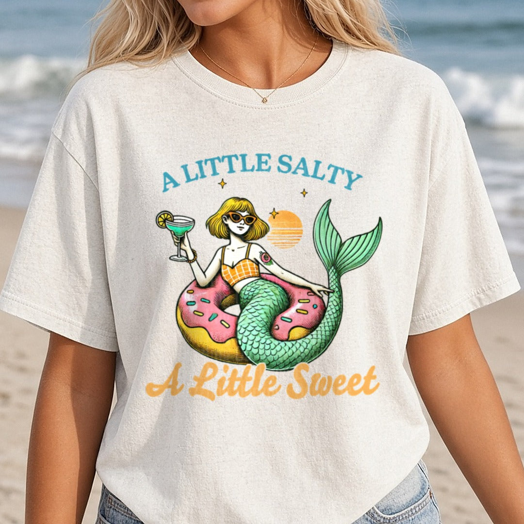 A Little Salty A Little Sweet Mermaid on Donut Float with Cocktail DTF transfer shown on a Comfort Colors tee