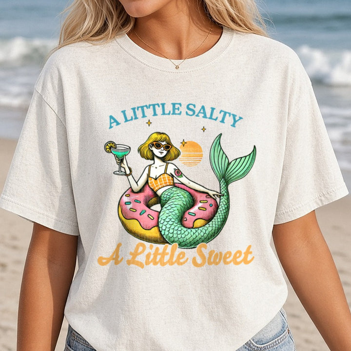 A Little Salty A Little Sweet Mermaid on Donut Float with Cocktail DTF transfer shown on a Comfort Colors tee