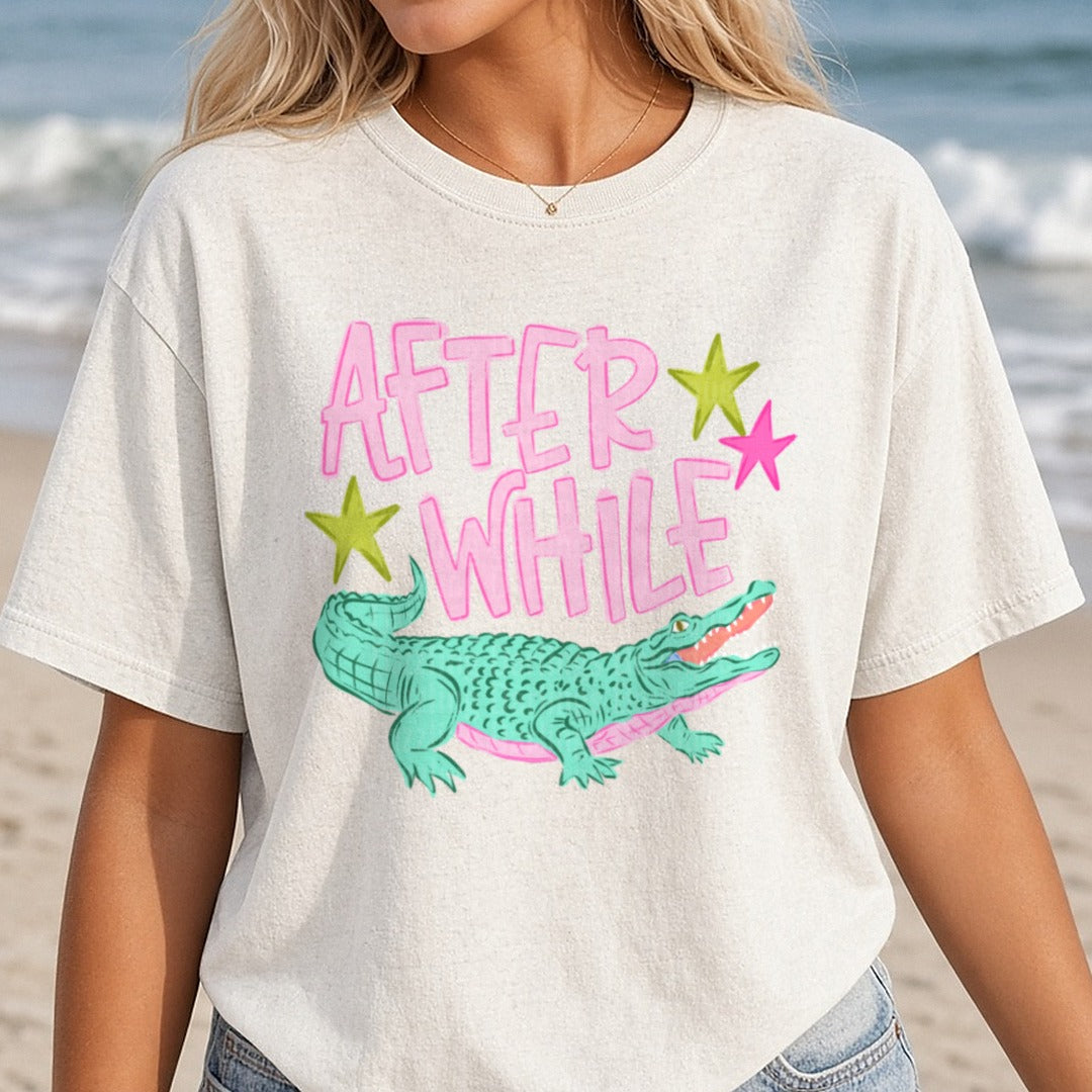 After While Crocodile Pink Text with Green Alligator and Stars DTF transfer shown on a Comfort Colors tee