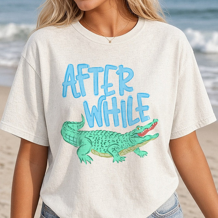 After While Crocodile Blue Text Green Alligator Design DTF transfer shown on a Comfort Colors tee