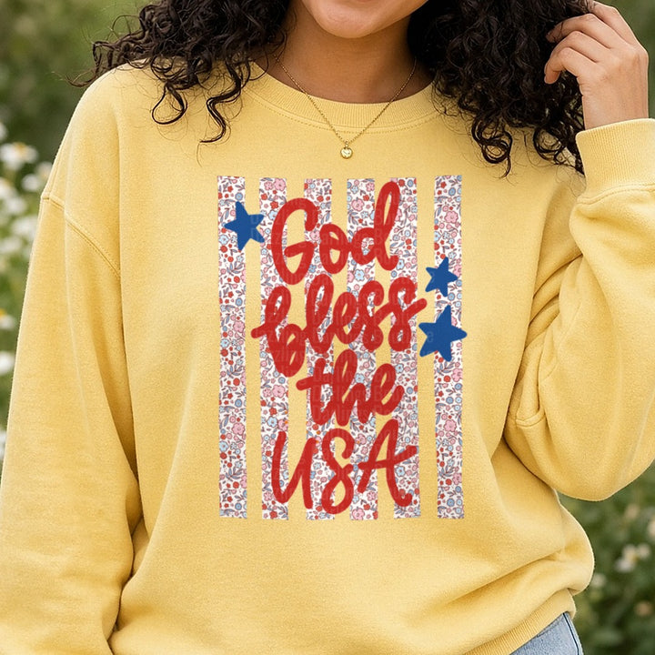God Bless the USA Patriotic Typography with Stars and Floral Pattern DTF transfer shown on a Comfort Colors sweatshirt