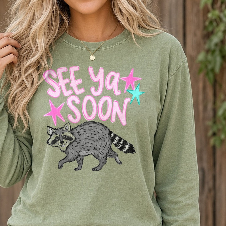 See Ya Soon Raccoon with Pink Stars DTF transfer shown on a Comfort Colors long sleeve tee
