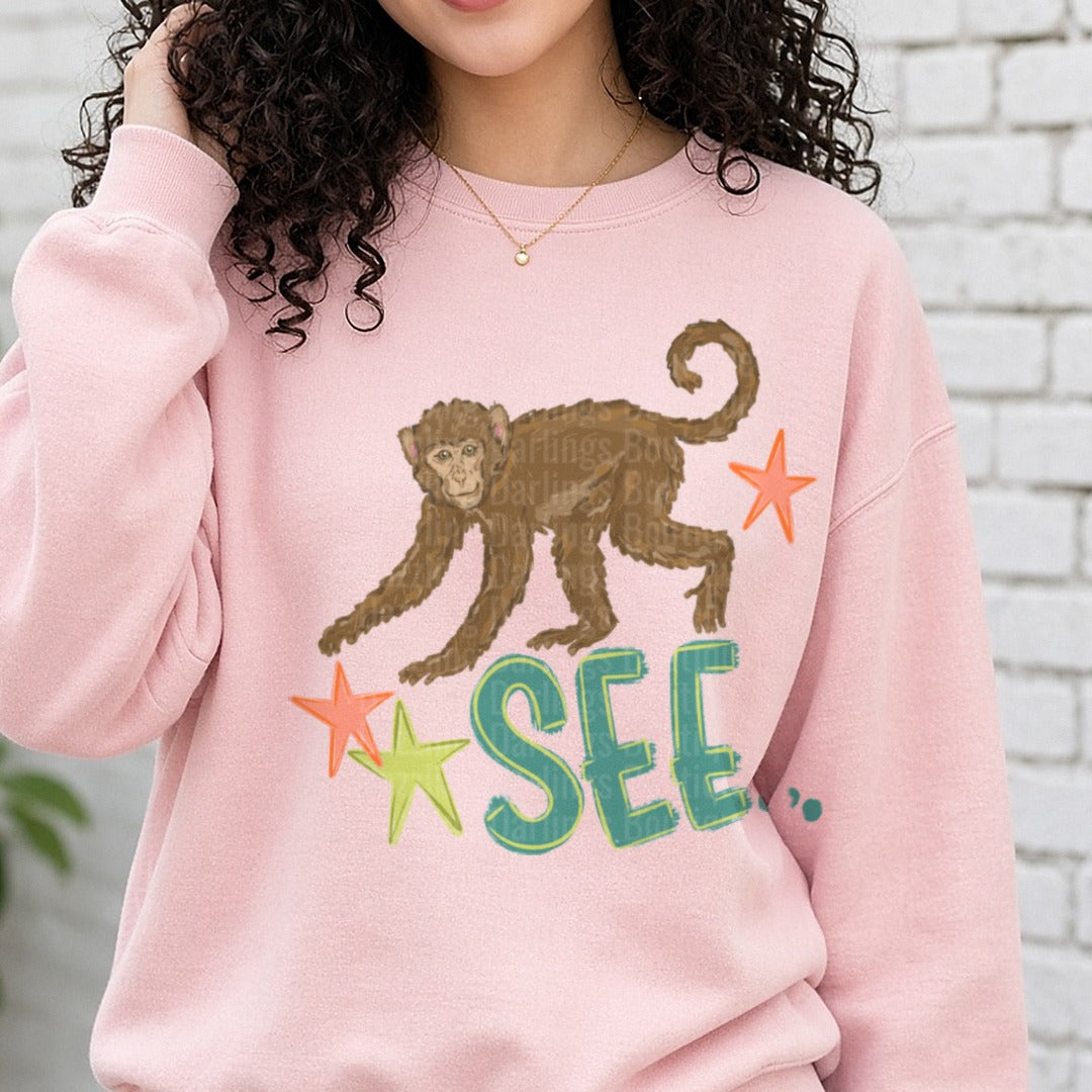 Monkey See Stars Playful Primate Design DTF transfer shown on a Comfort Colors sweatshirt