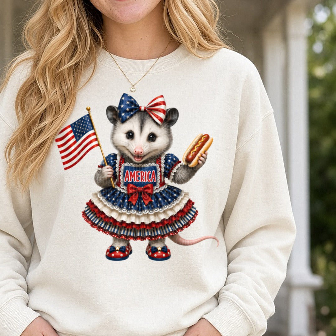 Patriotic Opossum in American Flag Dress Holding Hot Dog and Flag DTF transfer shown on a Comfort Colors sweatshirt