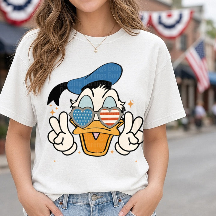 Donald Duck Patriotic Heart Sunglasses Peace Signs 4th of July DTF transfer shown on a Comfort Colors tee