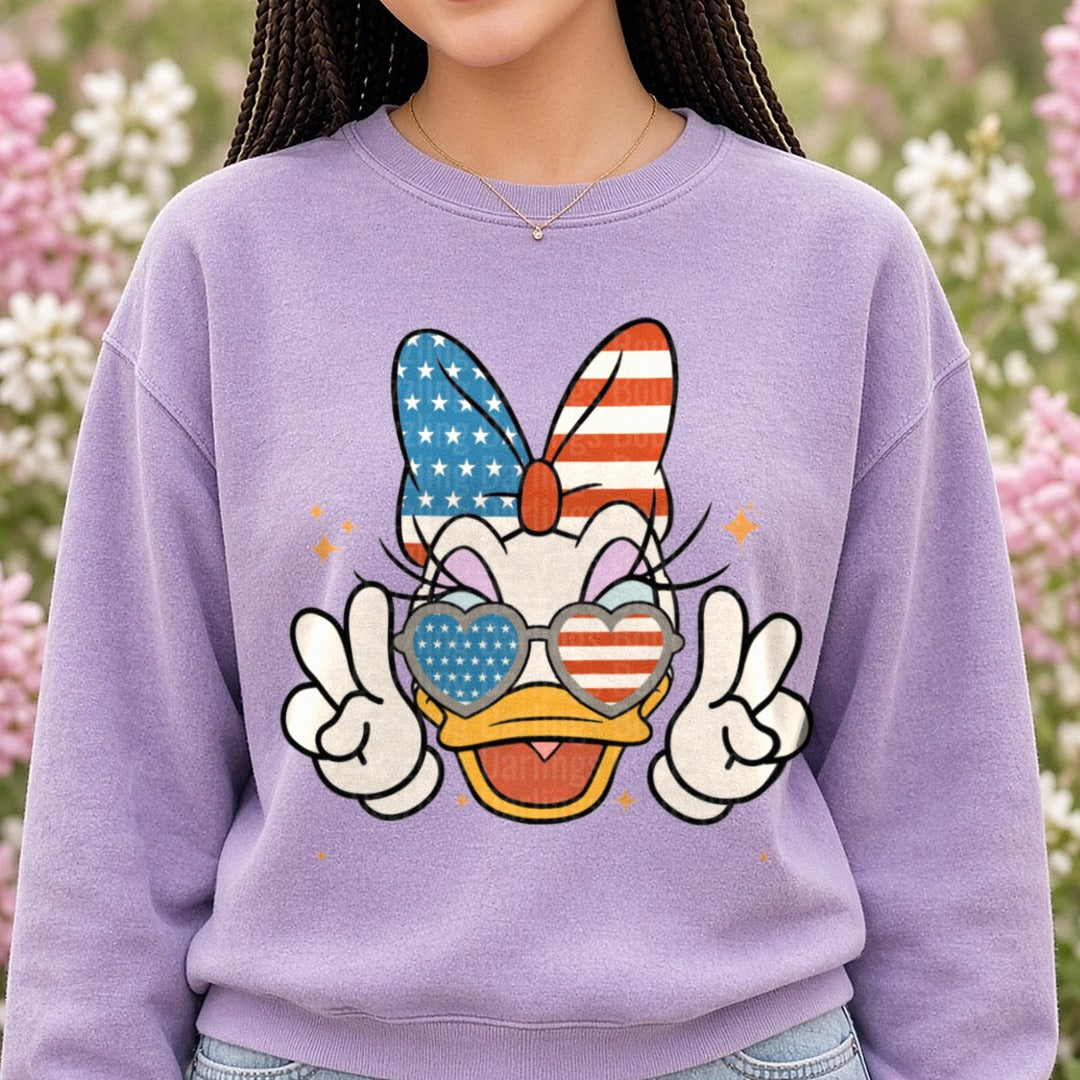 Daisy Duck Patriotic USA Flag Bow Heart Sunglasses Peace Sign DTF transfer shown on a Comfort Colors sweatshirt