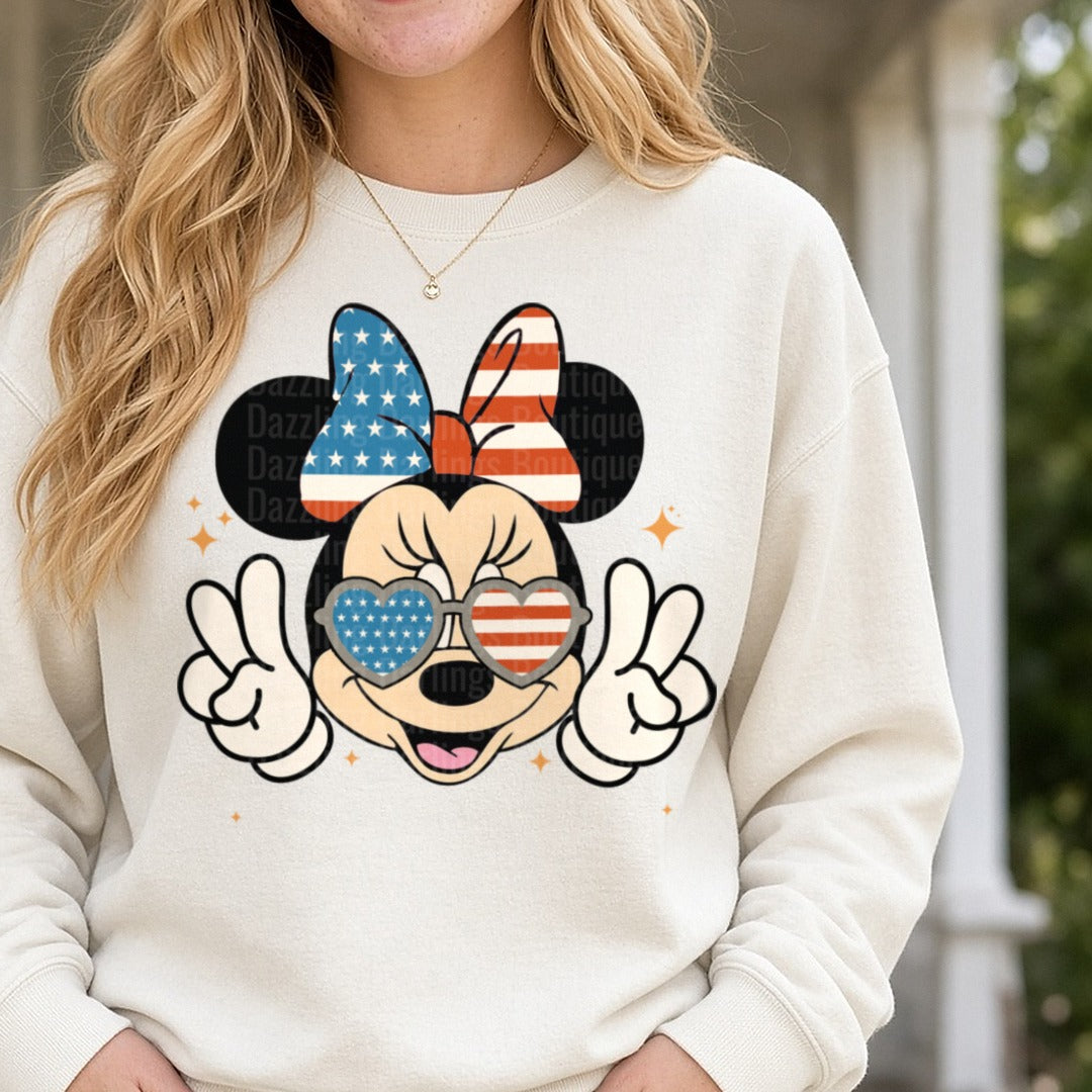 Patriotic Minnie Mouse Heart Sunglasses Peace Signs USA Flag Bow DTF transfer shown on a Comfort Colors sweatshirt