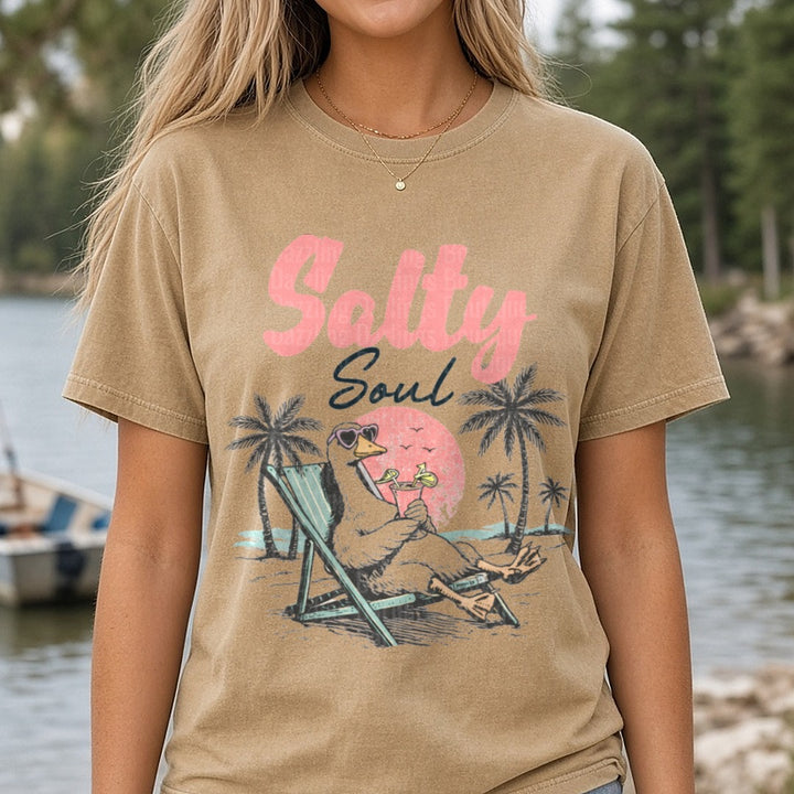 Salty Soul Beach Duck Relaxing in Lounge Chair with Cocktail DTF transfer shown on a Comfort Colors tee