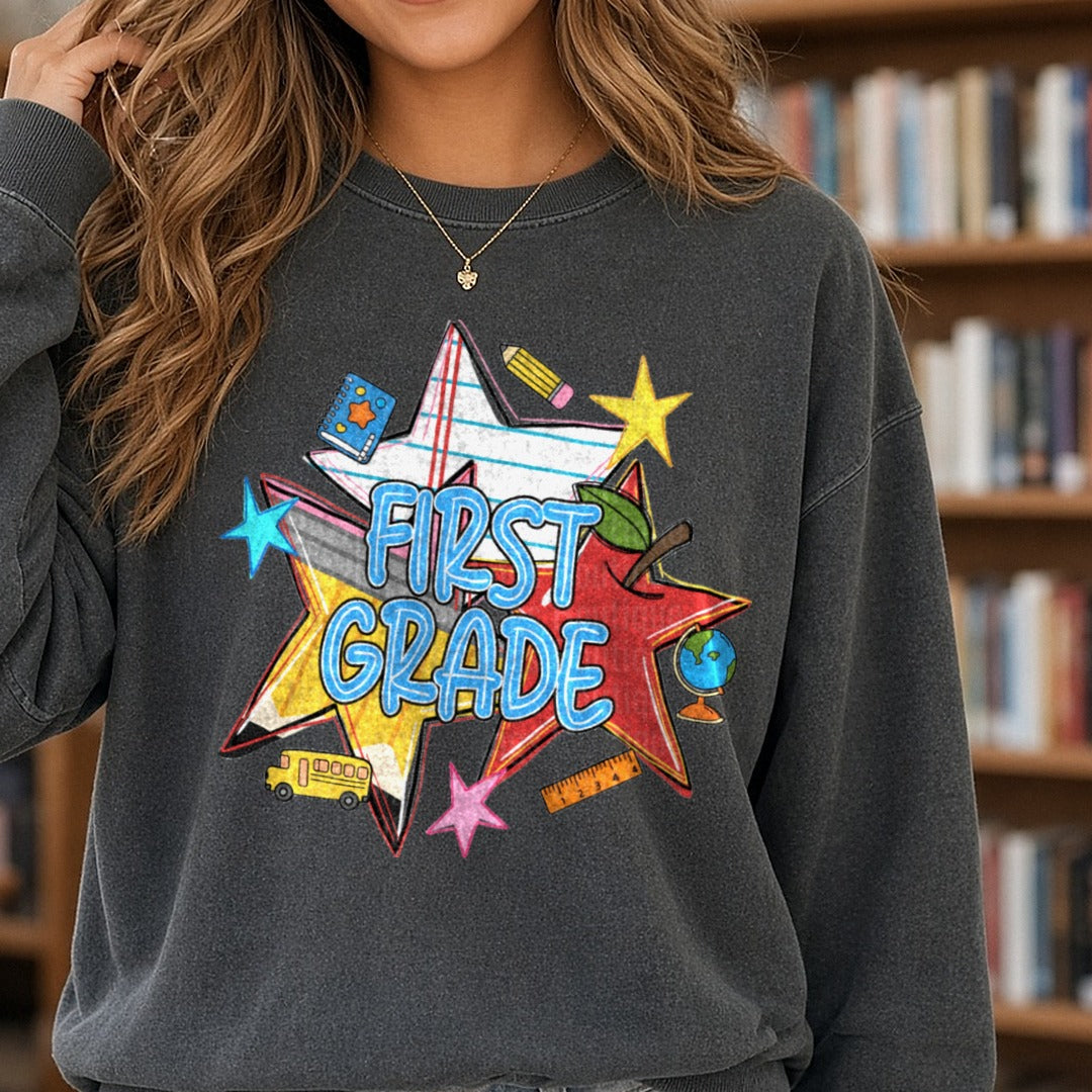 First Grade Back to School Stars Pencil Apple Bus Design DTF transfer shown on a Comfort Colors sweatshirt