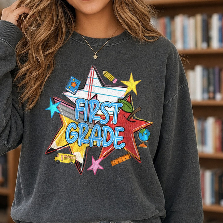 First Grade Back to School Stars Pencil Apple Bus Design DTF transfer shown on a Comfort Colors sweatshirt