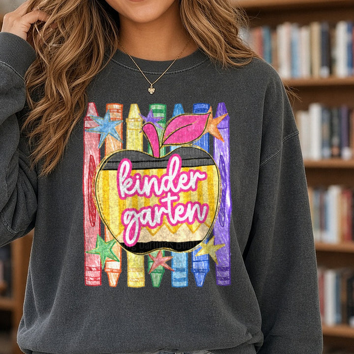 Kindergarten Rainbow Crayons Apple Back to School Design DTF transfer shown on a Comfort Colors sweatshirt